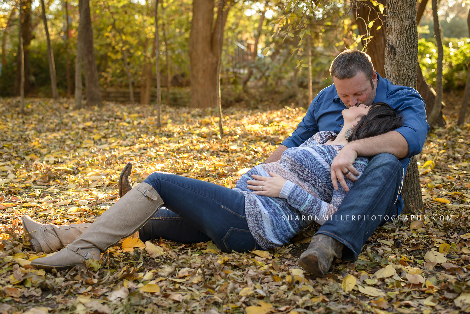 maternity photo of kissing in the fall leaves at Grapevine Botanical Gardens