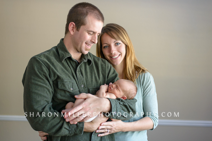 at home portrait of parents with newborn baby boy
