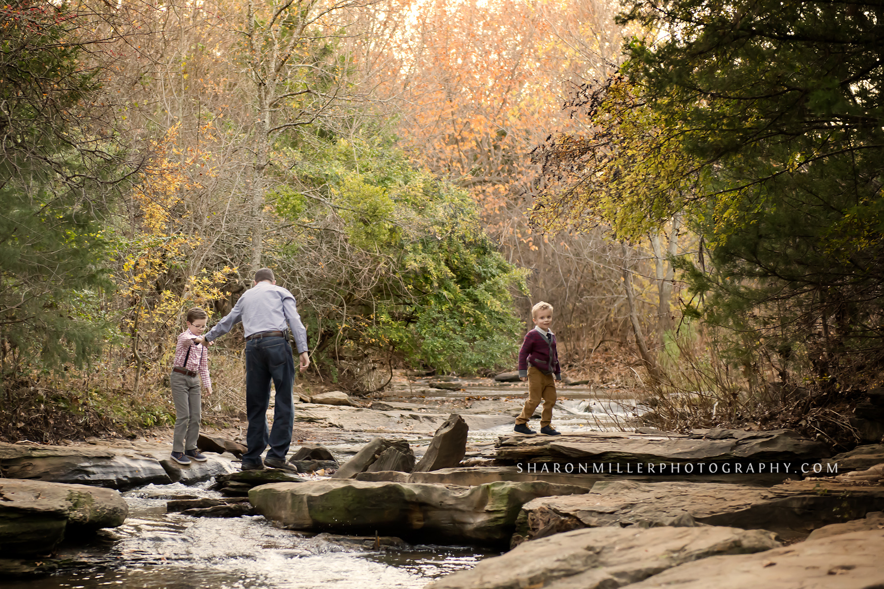 boys and their dad crossing Stone Creek by Flower Mound family photographer Sharon Miller