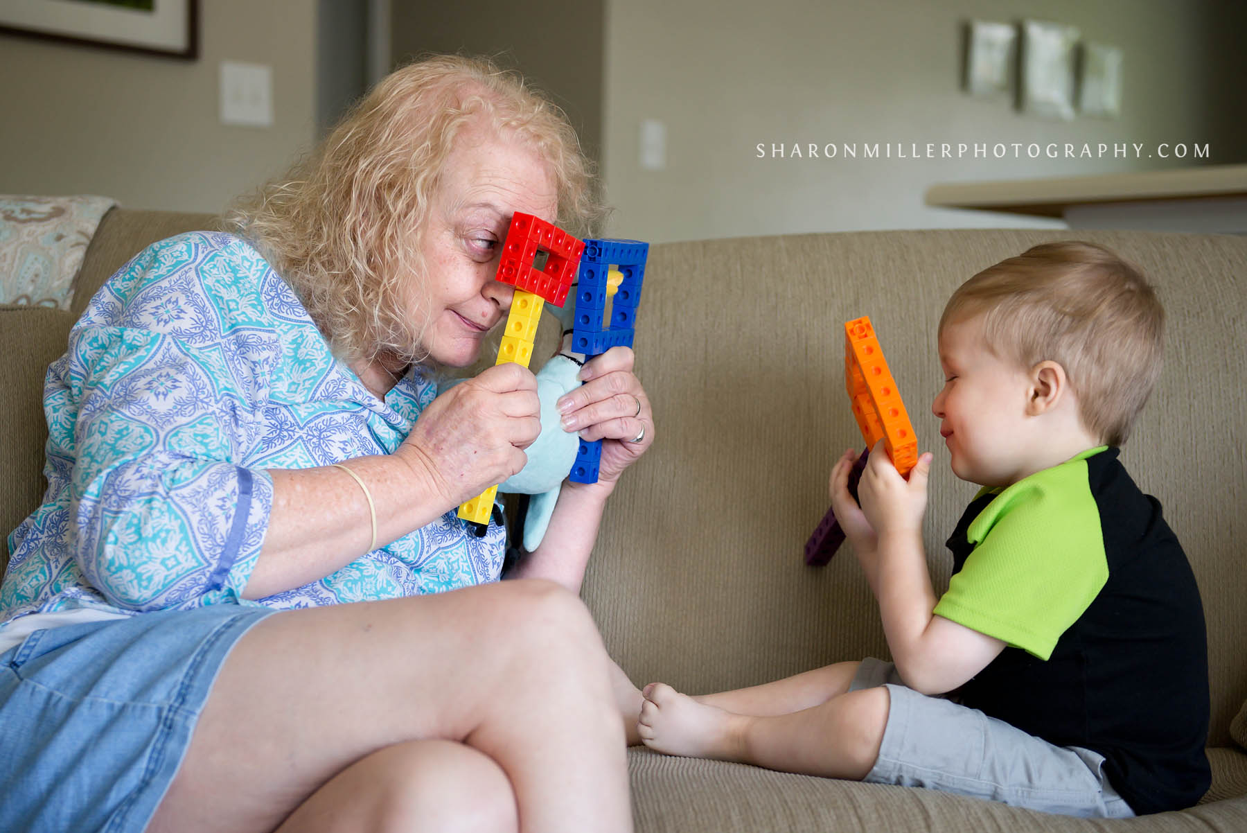 Grandma playing with grandson using pretend masks made of blocks