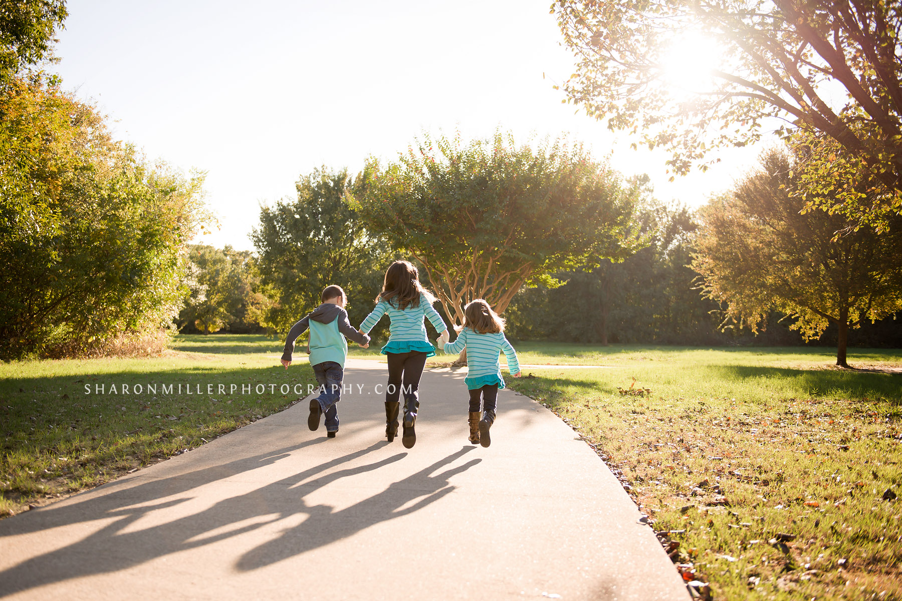 photo of children running through the park holding hands during a Grapevine family lifestyle session