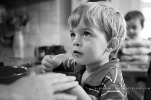 boy eating an apple at the kitchen counter