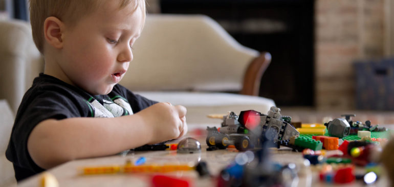 little boy playing with legos